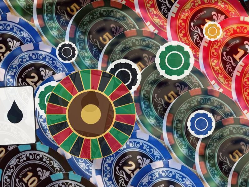 Colorful casino chips around a roulette wheel centerpiece with a white card showing a black droplet symbol.