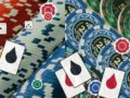 Pile of casino chips with playing cards and dice, conveying gambling theme.